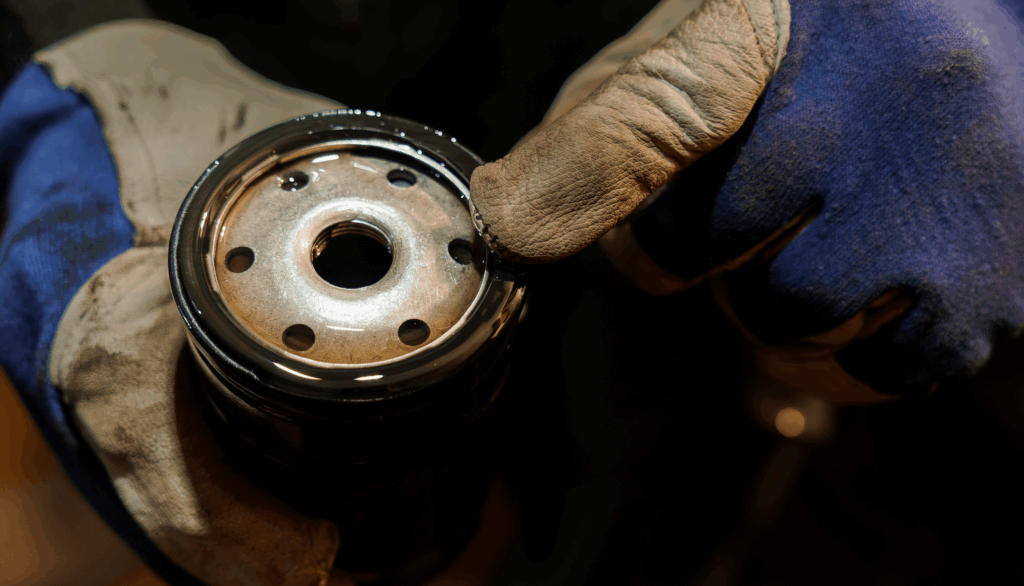 Close-up of a Mechanic Inspecting an Oil Filter with Gloved Hands.